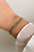 Bracelet Suzon argenté multi-rangs texturés en acier inoxydable, porté au poignet