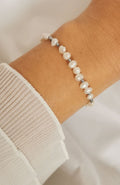 Bracelet Polynésie argenté avec perles d'eau douce sur chaîne en acier inoxydable, porté au poignet