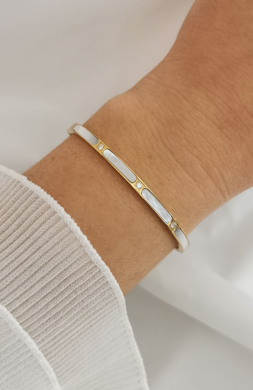 Bracelet jonc Malaga en acier inoxydable doré avec segments de nacre blanche et éclats scintillants
