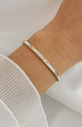 Bracelet jonc Malaga en acier inoxydable doré avec segments de nacre blanche et éclats scintillants