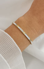 Bracelet jonc Malaga en acier inoxydable doré avec segments de nacre blanche et éclats scintillants