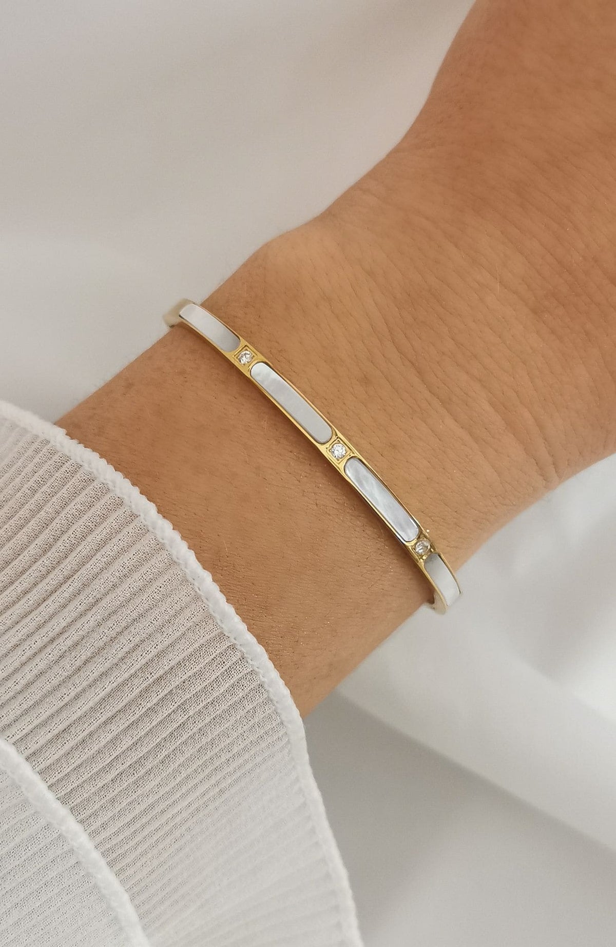 Bracelet jonc Malaga en acier inoxydable doré avec segments de nacre blanche et éclats scintillants