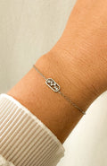 Bracelet Héloïse argenté avec pendentif constellation serti de zircons, porté au poignet