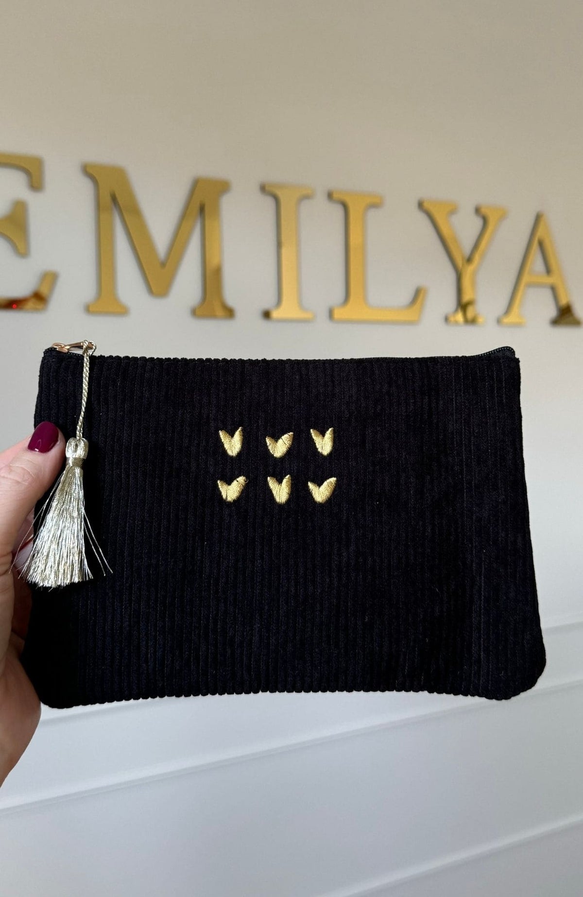 Pochette noire en velours côtelé avec cœurs brodés dorés et pompon