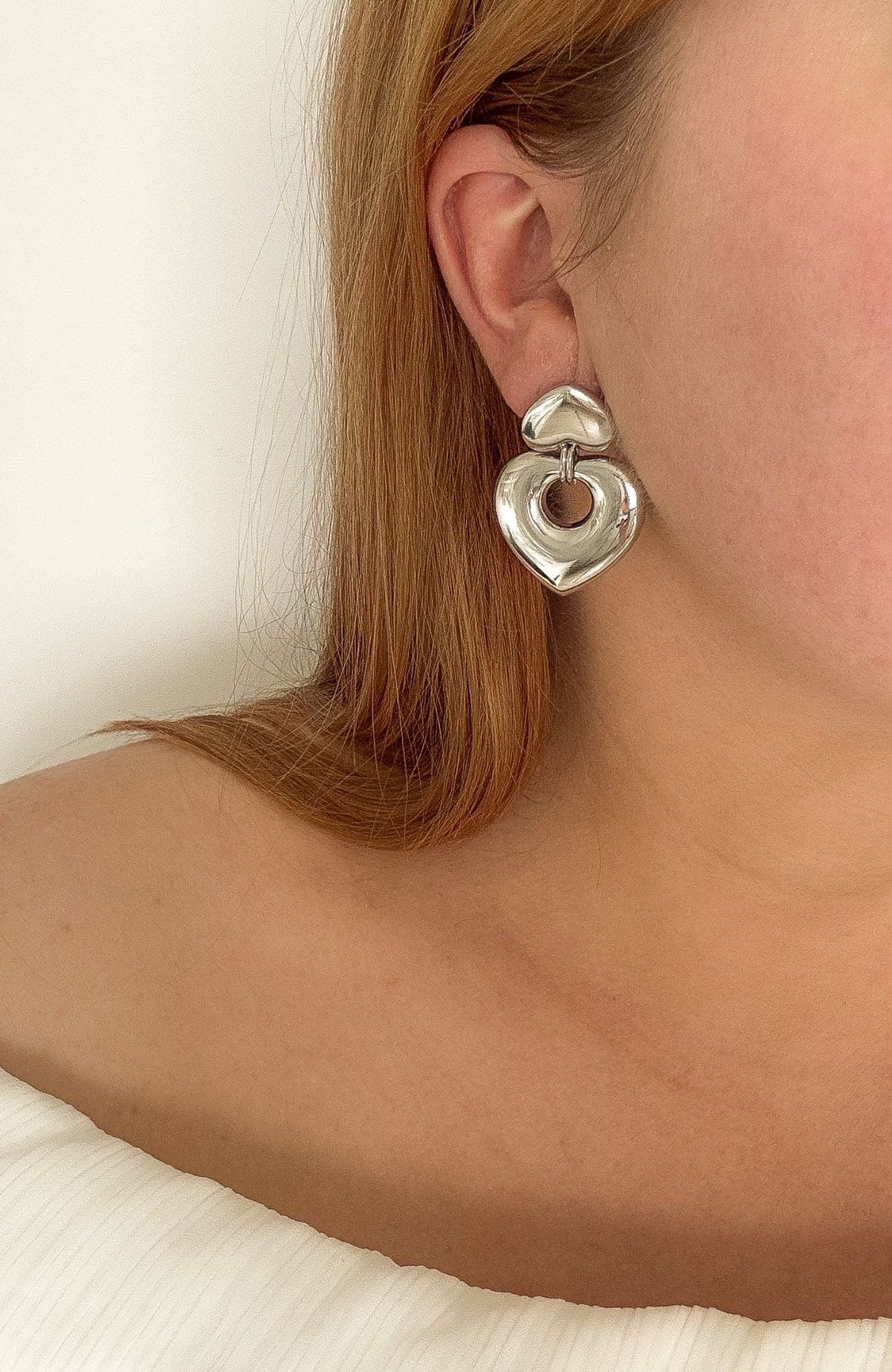 Boucles d'oreilles Estelle argentées portées, puce cœur avec pendentif anneau cœur