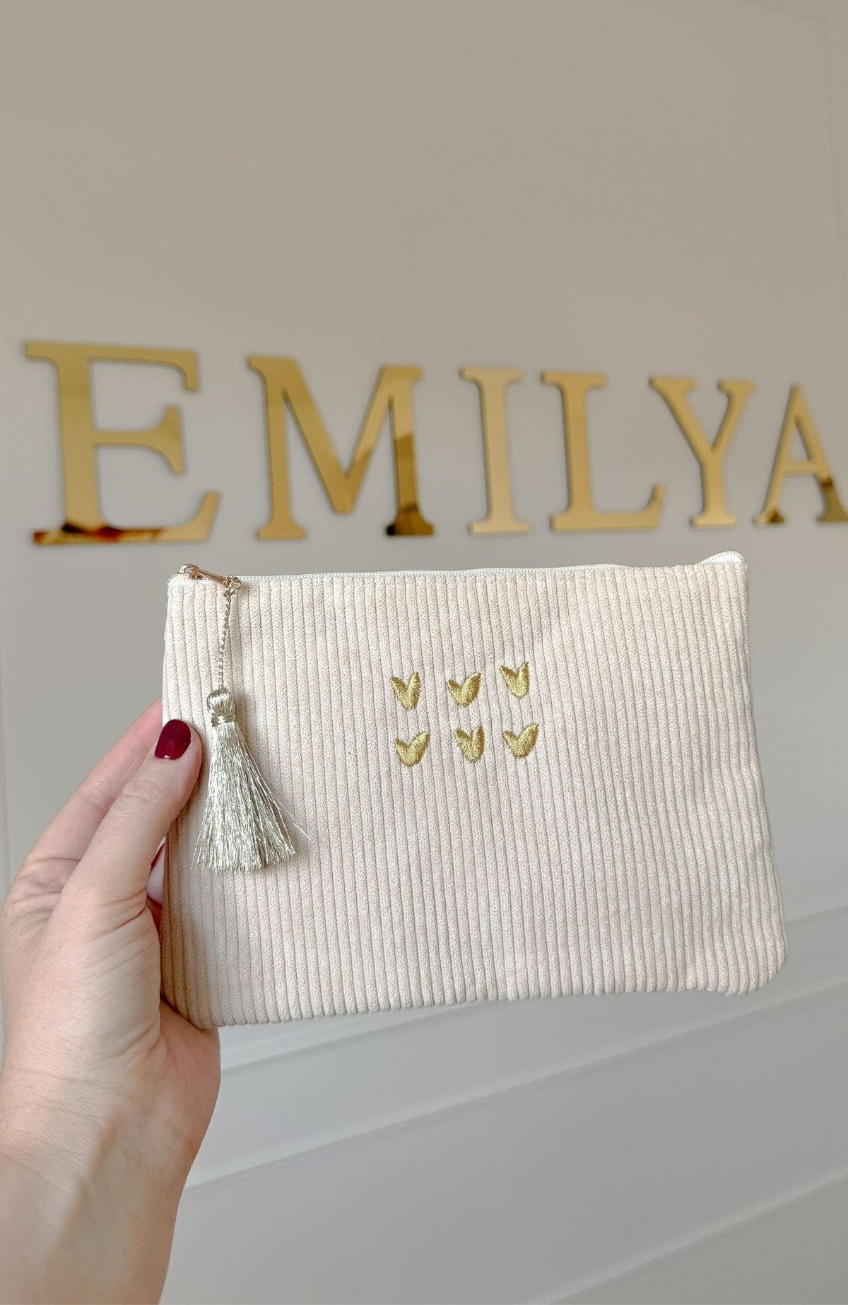 Pochette beige en velours côtelé avec cœurs brodés dorés et pompon